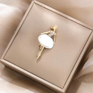 Détail d'une élégante broche ballerine dorée avec cristaux dans un écrin à bijoux