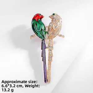Detail view of double bird brooch with enamel and rhinestones showing 6.6x3.2cm size