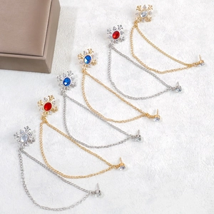 Detailed view of elegant cross and tassel chain brooches with colorful rhinestones