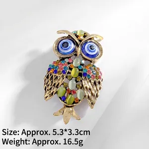 Detailed view of vintage gold owl brooch with colorful crystals and evil eye accent