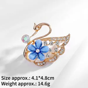 Detailed swan brooch with blue flower and crystal pave, measuring 4.1x4.8cm