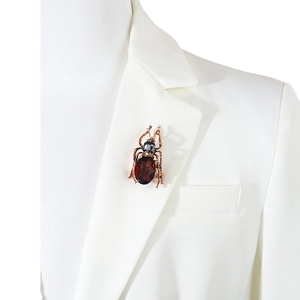 Exquisite Käfer-Insektenbrosche mit tiefrotem Edelstein an einem weißen Revers