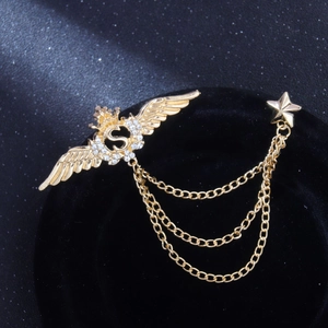 Broche baroque dorée avec ailes, lettre S et chaînes étoiles pour costume homme