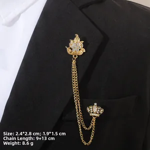Détail de broche baroque dorée à chaîne avec motifs fleur et couronne sur costume