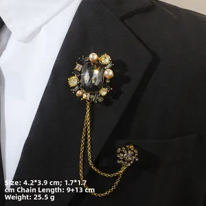 Détail d'une broche vintage baroque avec pierres noires et perles sur un revers noir