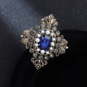 Vintage European style brooch with sapphire blue gem and pearls on a golden base