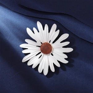 Detailed macro shot of a white enamel daisy brooch with a textured brown center