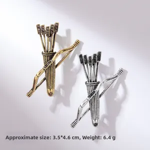 Detailansicht der Vintage Bogen und Pfeil Broschen in Gold und Silber mit Strasssteinen