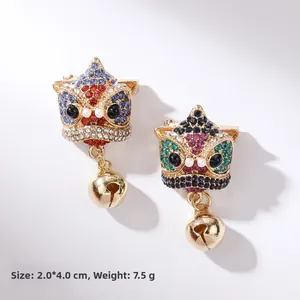 Macro detail of Chinese lion dance brooch with colorful rhinestones and gold bell