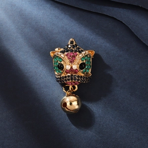Close-up of a Chinese lion dance brooch with colorful rhinestones and a gold bell