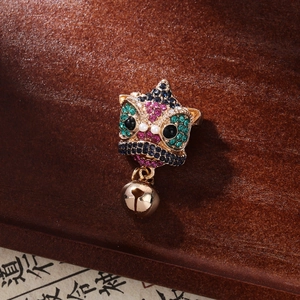 Detailed close-up of a Chinese lion brooch with colorful rhinestones and a gold bell