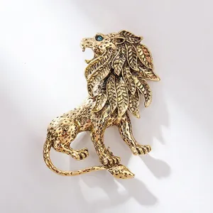 Vintage lion head brooch in gold alloy with emerald green rhinestone eyes and fine details