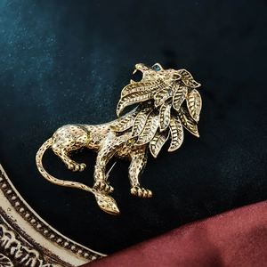 Macro detail of vintage lion brooch with gold finish, blue gem eyes on black velvet