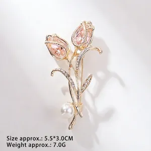 Detailweergave van tulpenbroche met roze kristallen, strassteentjes en witte parel