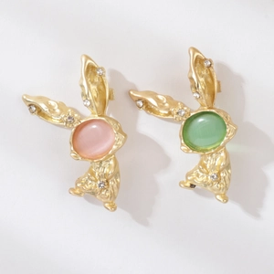 Détail de broches lapins en or vintage avec pierres rose et verte et strass