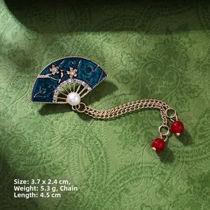 Detailed view of a fan-shaped brooch with blue enamel and pearl on vintage board