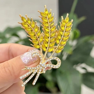 Elegante gouden tarwebroche met gele kristallen en witte strass strik op een kostuum