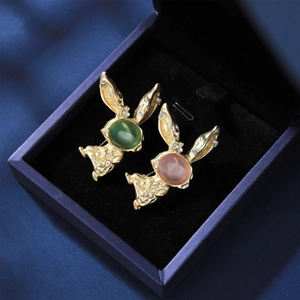 Détail de broches lapin dorées avec pierres œil de chat et zircons étincelants