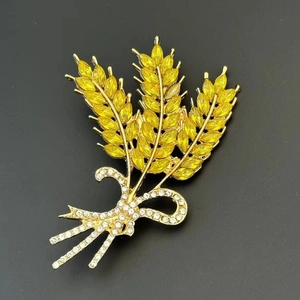 Macro-opname van tarwe-broche met gele edelstenen en een strik met witte kristallen