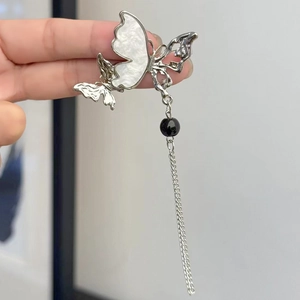 Broche papillon argentée avec incrustation en nacre et long pompon en chaîne métallique