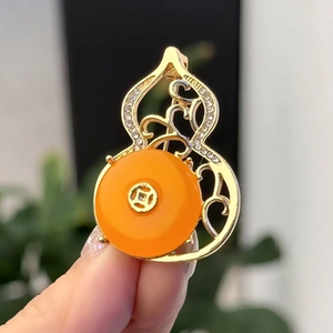 Vintage gold gourd brooch with orange gemstone and pavé diamonds in traditional style