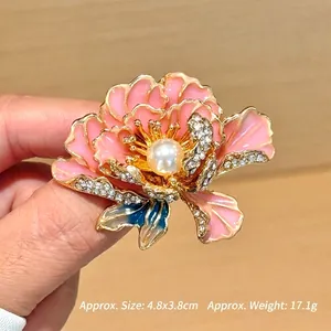 Detailopname van roze emaille pioenroos broche met parel en strass details