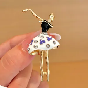 Detail view of gold ballet dancer brooch with purple heart and size markers