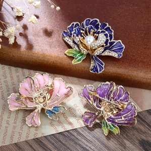 Macro-detail van geëmailleerde pioenroos broche met strass, parels en veiligheidsspeld