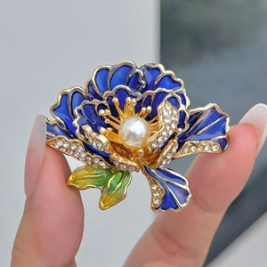 Vintage blauwe pioenroos broche met gouden details en een grote parel in het midden