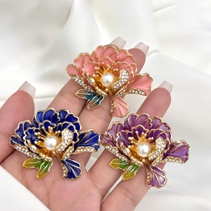 Detailopname van handgemaakte pioenroos broches met strassteentjes en parels