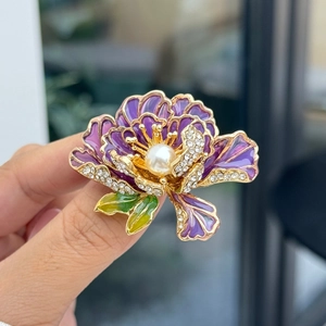 Detail van een paarse emaille pioenroos broche met diamanten accenten en een witte parel