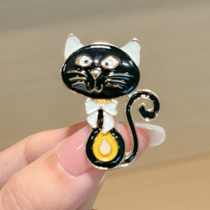 Mignonne broche chat en émail noir avec nœud blanc et motif goutte jaune