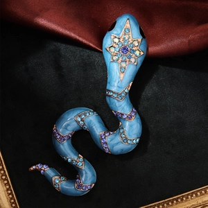 Macro shot of blue enamel snake brooch with sparkling rhinestones and golden stars