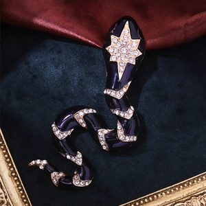 Macro detail of vintage snake brooch with black enamel and starburst crystal accents