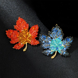 Exquisite gold-plated maple leaf brooch set with vibrant rhinestones on black background