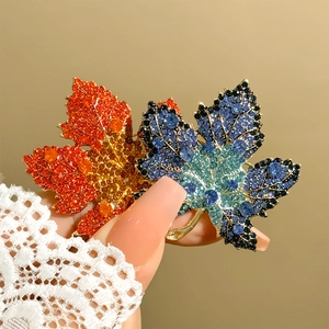 Detail of maple leaf brooch with vibrant rhinestone gradients in blue and orange