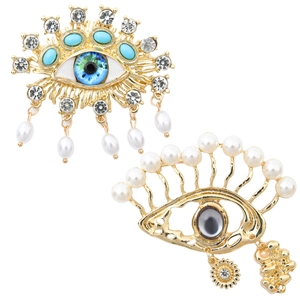 Detailed macro view of baroque evil eye brooches with tassels and hanging pearls