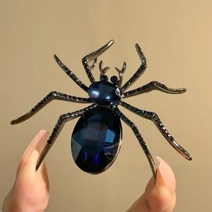 Dettaglio macro di spilla ragno gotico con gemme blu scuro e strass neri micro-intarsiati