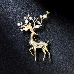 Détail macro d'une broche élan dorée élégante avec perles blanches et strass brillants