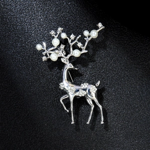 Vue détaillée d'une élégante broche élan argentée avec perles blanches et strass brillants
