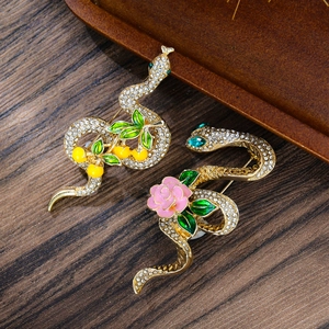 Elegant gold snake brooch set with white rhinestones, flowers and cherry leaf accents