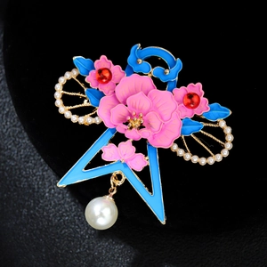 Macro shot of retro flower brooch with pink petals, blue enamel leaves and pearls