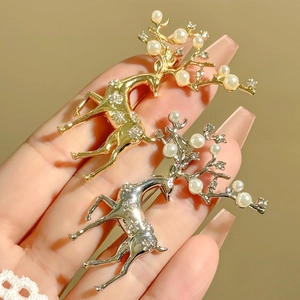 Détail de broches cerf élégantes en or et argent avec strass et perles blanches