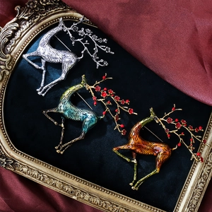 Vintage enamel deer brooches with plum blossom antlers on elegant dark velvet