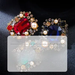 Macro shot of vintage alloy brooches with emerald, ruby, and sapphire-colored gemstones