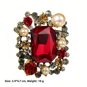 Detailed close-up of a vintage brooch featuring a large red gemstone and pearls