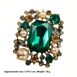 Detailed macro shot of luxury vintage brooch showing size 3.9x4.7cm and emerald crystal