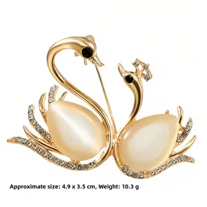 Detail view of gold swan brooch with pear-shaped cat-eye stone and small crystals