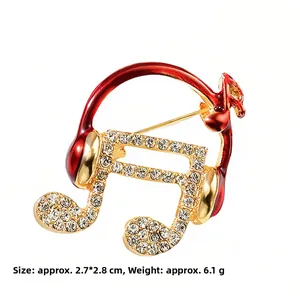 Elegante broche de auriculares con nota musical dorada con esmalte rojo y circonitas