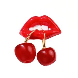 Creative red lips and cherry brooch with glossy enamel finish on a white background
